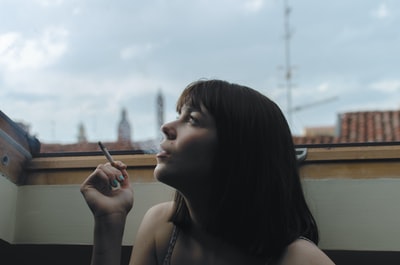 女人拿着棍子香烟在白天时间

